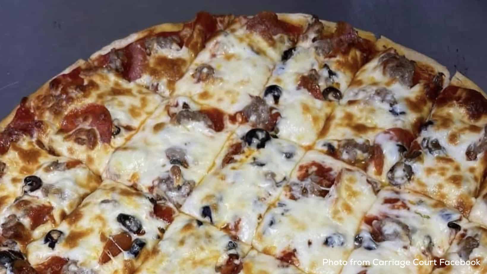 Thin crust pizza with sausage pepperoni and olives